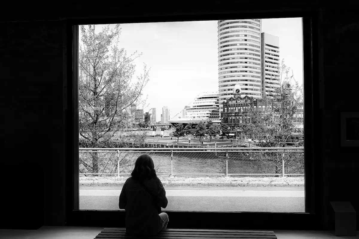 Vrouw kijkt naar buiten vanuit het Feniks museum